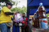 Aktivis lingkungan melayani warga menukarkan sampah botol plastik dengan tiket wisata susur Sungai Cisadane di Karawaci, Kota Tangerang, Banten, Sabtu (20/9/2025). Pemerintah Kota Tangerang bersama Yayasan Jaringan Aktivis Lingkungan Hidup Indonesia meluncurkan Program Inovasi Hijau Berkelanjutan berupa penukaran sampah botol plastik atau minyak jelantah dengan tiket wisata edukasi susur Sungai Cisadane guna mendorong kesadaran kolektif masyarakat dalam mengelola sampah. ANTARA FOTO/Putra M. Akbar/gp