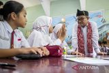 Menteri Pendidikan Dasar dan Menengah (Mendikdasmen) Abdul Mu'ti (kanan) berbincang dengan siswa saat kunjungan kerja di SDN Cimahi Mandiri 1, Kota Cimahi, Jawa Barat, Senin (22/9/2025). Dalam kunjungan kerjanya, Mendikdasmen meninjau sarana dan prasarana, proses pembelajaran menggunakan papan interaktif (smartboard) serta memberikan arahan pada pelatihan guru bimbingan konseling (BK) di sekolah dasar. ANTARA FOTO/Abdan Syakura/agr