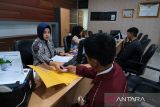 Petugas melayani pemohon yang mengajukan penerbitan Surat Keterangan Catatan Kepolisian (SKCK) di Sentra Pelayanan Kepolisian Terpadu (SPKT) Polresta Pontianak, Kalimantan Barat, Jumat (19/9/2025). Berdasarkan data Sat Intelkam Polresta Pontianak, sejak 15 hingga 19 September 2025 tercatat sekitar 600 pemohon SKCK untuk keperluan verifikasi persyaratan administrasi pemberkasan Pegawai Pemerintah dengan Perjanjian Kerja (PPPK) paruh waktu serta pendaftaran prajurit TNI. ANTARA FOTO/Jessica Wuysang