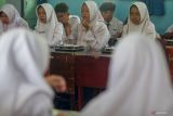 Siswa menyantap makanan bergizi gratis di SMPN 1 Sidoarjo, Jawa Timur, Selasa (23/9/2025). Pemprov Jawa Timur menyatakan pada 19 September lalu, pelaksanaan program strategis pemerintah Makan Bergizi Gratis (MBG) telah dirasakan oleh 2,7 juta masyarakat penerima manfaat dari 10 juta penerima yang ditargetkan. Antara Jatim/Umarul Faruq