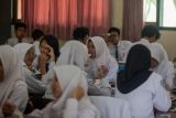 Siswa menyantap makanan bergizi gratis di SMPN 1 Sidoarjo, Jawa Timur, Selasa (23/9/2025). Pemprov Jawa Timur menyatakan pada 19 September lalu, pelaksanaan program strategis pemerintah Makan Bergizi Gratis (MBG) telah dirasakan oleh 2,7 juta masyarakat penerima manfaat dari 10 juta penerima yang ditargetkan. Antara Jatim/Umarul Faruq
