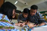 Tiga siswa mengakses materi pelajaran melalui aplikasi sekolah secara daring menggunakan gawai saat peluncuran program internet gratis untuk sekolah di SMAN 1 Pontianak, Kalimantan Barat, Selasa (23/9/2025). Pemerintah Provinsi Kalbar bersama PT Solusi Sinergi Digital Tbk dan Huawei Indonesia meluncurkan program internet gratis berkecepatan 100 Mbps melalui program CSR untuk satuan pendidikan se-Kalimantan Barat guna menghadirkan pemerataan literasi digital dan peningkatan kualitas pendidikan. ANTARA FOTO/Jessica Wuysang
