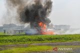 Suasana replika pesawat yang terbakar saat simulasi keadaan darurat di Bandara Husein Sastranegara, Bandung, Jawa Barat, Rabu (24/9/2025). PT Angkasa Pura II bersama Lanud Husein Sastranegara menggelar simulasi keadaan darurat yang ditujukan untuk menguji prosedur penanganan keadaan darurat sekaligus memperkuat koordinasi antara pihak bandara, TNI AU, Basarnas, aparat keamanan, tenaga medis, dan instansi terkait lainnya. ANTARA FOTO/Raisan Al Farisi/agr