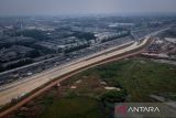 Foto udara kendaraan melintas di dekat proyek pembangunan akses tol langsung KM 25 Jakarta-Merak di Curug, Kabupaten Tangerang, Banten, Kamis (25/9/2025). Pembangunan akses tol sepanjang 10 kilometer serta  Gerbang Tol Bitung 3 tersebut progresnya sudah mencapai 80 persen dan ditargetkan selesai akhir tahun 2025 guna mengurangi kemacetan di Jalan Arteri Bitung. ANTARA FOTO/Putra M. Akbar/gp