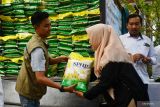 Petugas melayani warga yang membeli beras saat digelar pasar murah di Kota Madiun, Jawa Timur, Jumat (26/9/2025). Pasar murah yang digelar Pemprov Jawa Timur itu menyediakan sejumlah kebutuhan pokok antara lain beras, minyak goreng, telur ayam ras, daging ayam, gula pasir, bawang merah, bawang putih lebih murah Rp2.500 hingga Rp7.000 per kilogram dibandingkan harga pasar guna pengendalian inflasi dan ketahanan pangan. Antara Jatim/Siswowidodo/um