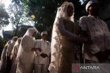 Pasangan calon pengantin berjalan untuk melaksanakan akad nikah secara gratis di depan Mal Pelayanan Publik Kota Bandung, Bandung, Jawa Barat, Jumat (26/9/2025). Pemerintah Kota Bandung menggelar nikah gratis bagi 10 pasangan dengan sekaligus menyediakan buku nikah, rias pengantin, mahar hingga kartu keluarga secara langsung sebagai bentuk pelayanan terpadu bagi masyarakat. ANTARA FOTO/Novrian Arbi/agr