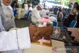 Pasangan calon pengantin melaksanakan akad nikah secara gratis di depan Mal Pelayanan Publik Kota Bandung, Bandung, Jawa Barat, Jumat (26/9/2025). Pemerintah Kota Bandung menggelar nikah gratis bagi 10 pasangan dengan sekaligus menyediakan buku nikah, rias pengantin, mahar hingga kartu keluarga secara langsung sebagai bentuk pelayanan terpadu bagi masyarakat. ANTARA FOTO/Novrian Arbi/agr