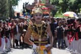 Warga mengikuti kirab budaya sedekah bumi di kawasan Made, Surabaya, Jawa Timur, Minggu (28/9/2025). Tradisi sedekah bumi dengan mengarak gunungan hasil pertanian itu dilakukan setahun sekali sebagai wujud rasa syukur kepada Tuhan Yang Maha Esa atas limpahan rezeki, sekaligus untuk menjaga kerukunan antarwarga dan melestarikan budaya setempat. Antara Jatim/Didik Suhartono/um