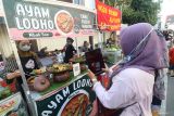 Warga menyiapkan aplikasi OCTO Mobile CIMB Niaga untuk membeli makanan melalui Quick Response Indonesia Standar (QRIS) di Kota Kediri, Jawa Timur, Minggu (28/9/2025). PT Bank CIMB Niaga Tbk memiliki 9,1 juta nasabah di seluruh Indonesia dan konsisten berinovasi menghadirkan produk layanan relevan kepada masyarakat di antaranya memperkuat transformasi digital melalui layanan aplikasi OCTO Mobile yang terus disempurnakan. ANTARA Jatim/Prasetia Fauzani/mas.