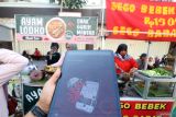 Warga menyiapkan aplikasi OCTO Mobile CIMB Niaga untuk membeli makanan melalui Quick Response Indonesia Standar (QRIS) di Kota Kediri, Jawa Timur, Minggu (28/9/2025). PT Bank CIMB Niaga Tbk memiliki 9,1 juta nasabah di seluruh Indonesia dan konsisten berinovasi menghadirkan produk layanan relevan kepada masyarakat di antaranya memperkuat transformasi digital melalui layanan aplikasi OCTO Mobile yang terus disempurnakan. ANTARA Jatim/Prasetia Fauzani/mas.