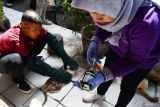 Dokter hewan menyiapkan vaksin rabies untuk disuntikkan pada seekor kucing di kawasan Pasar Besar Kota Madiun, Jawa Timur, Senin (29/9/2025). Dinas Ketahanan Pangan dan Pertanian Kota Madiun melakukan vaksinasi rabies pada kucing jalanan di delapan lokasi sebagai pencegahan penyakit rabies guna terciptanya keamanan dan kenyamanan lingkungan dalam rangka memperingati Hari Rabies Sedunia. ANTARA Jatim/Siswowidodo/mas.