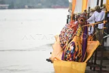 Masyarakat Adat Kutai mengikat replika naga Erau di perahu saat ritual mengulur naga pada Puncak Erau Adat Kutai 2025 di Sungai Mahakam, Tenggarong, Kutai Kartanegara, Kalimantan Timur, Minggu (28/9/2025). Ritual mengulur replika naga laki dan bini (perempuan) di hulu Sungai Mahakam yang berada di kawasan Kutai Lama, Kecamatan Anggana itu merupakan bentuk penyucian diri dan memohon perlindungan dari unsur jahat, baik yang tampak maupun tidak. Antara Kaltim/M Risyal Hidayat