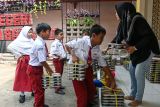 Wali murid membagikan ompreng berisi makanan kepada siswa di SDN Pejaten Barat 1 Pagi, Jakarta, Selasa (30/9/2025). Pihak sekolah melibatkan komite orang tua murid untuk membantu guru dalam pendistribusian makanan dalam program makan bergizi gratis (MBG) kepada 580 siswa sekaligus melakukan pengawasan langsung agar menjamin mutu kesehatan makanan yang akan dikonsumsi siswa. ANTARA FOTO/Sulthony Hasanuddin/tom.