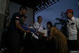 Petugas gabungan menyerahkan bantuan terpal dan bahan pangan kepada salah satu korban bencana puting beliung di Tulungagung, Jawa Timur, Rabu (1/10/2025). Hujan disertai angin kencang (puting beliung) melanda tiga desa di wilayah kecamatan Sumbergempol, Tulungagung dan menyebabkan satu rumah rusak berat dan puluhan bangunan lain rusak ringan-sedang. Antara Jatim/Destyan Sujarwoko/um