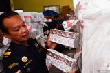 Petugas bea cukai memperlihatkan rokok ilegal (tanpa pita cukai) hasil sitaan di kantor Bea Cukai Madiun, Jawa Timur, Rabu (1/10/2025). Tim Bea Cukai Madiun menangkap pengemudi truk boks serta menyita rokok ilegal sebanyak 1,5 juta batang saat diangkut dari Madura menuju Jawa Barat di jalan tol ruas Ngawi-Kertosono, Minggu (21/9) yang mengakibatkan kerugian negara Rp1,5 miliar, dan saat ini masih dalam pengembangan penyelidikan. ANTARA Jatim/Siswowidodo/mas.