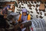 Pekerja menyelesaikan batik tulis di rumah produksi Deden Batik, Kota Tasikmalaya, Jawa Barat, Kamis (2/10/2025). Pada Hari Batik Nasional 2025 pelaku industri batik di Tasikmalaya berharap budaya batik terus dicintai dan dilestarikan serta mendukung keberadaan batik lokal. ANTARA FOTO/Adeng Bustomi/agr
