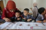 Siswa Taman Kanak Kanak (TK) didampingi gurunya mengikuti praktik belajar pengecatan kain batik di Rumah Batik Aceh, Banda Aceh, Aceh, Kamis (2/10/2025). Edukasi membatik untuk siswa TK dan SD  itu dalam rangka menyambut Hari Batik Nasional yang bertujuan memperkenal batik sebagai kekayaan budaya nasional yang telah diakui UNESCO untuk dilestarikan sebagai warisan tak benda dengan segala ragam keunikannya.ANTARA FOTO/Ampelsa.