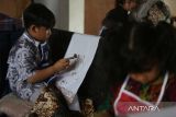 Sejumlah siswa Sekolah Dasar (SD)  didampingi gurunya mengikuti praktik belajar menggunakan canting  saat membatik di Rumah Batik Aceh, Banda Aceh, Aceh, Kamis (2/10/2025). Edukasi membatik untuk siswa TK dan SD itu dalam rangka menyambut Hari Batik Nasional yang bertujuan memperkenal batik sebagai kekayaan budaya nasional yang telah diakui UNESCO untuk dilestarikan sebagai warisan tak benda dengan segala ragam keunikannya.ANTARA FOTO/Ampelsa.