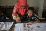Siswa Taman Kanak Kanak (TK) didampingi gurunya mengikuti praktik belajar pengecatan kain batik di Rumah Batik Aceh, Banda Aceh, Aceh, Kamis (2/10/2025). Edukasi membatik untuk siswa TK dan SD  itu dalam rangka menyambut Hari Batik Nasional yang bertujuan memperkenal batik sebagai kekayaan budaya nasional yang telah diakui UNESCO untuk dilestarikan sebagai warisan tak benda dengan segala ragam keunikannya.ANTARA FOTO/Ampelsa.