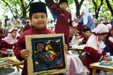 Peserta lomba memperlihatkan hasil karyanya saat mengikuti lomba membatik Gebyar Ayo Membatik dalam rangka memperingati Hari Batik Nasional di Kota Madiun, Jawa Timur, Kamis (2/10/2025). Lomba mewarnai batik yang digelar pengurus Ikatan Guru Taman Kanak-kanak Indonesia (IGTKI) bersama Persatuan Guru Republik Indonesia (PGRI) Provinsi Jawa Timur tersebut diikuti sekitar 400 anak TK dimaksudkan untuk memperkenalkan dan mengajak anak-anak mencintai batik sebagai warisan budaya. ANTARA Jatim/Siswowidodo/mas.