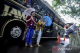Fotografer memotret model memeragakan busana batik di Kota Tangerang, Banten, Kamis (2/10/2025). Komunitas Taman Potret bersama Perempuan Berkebaya Indonesia menggelar kegiatan hunting foto parade batik di bus Jawara dalam rangka memperingati Hari Batik Nasional sekaligus mengasah kemampuan dan kreativitas pegiat fotografi. ANTARA FOTO/Putra M. Akbar/gp