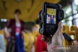 Fotografer memotret model memeragakan busana batik saat menaiki bus Jawara di Kota Tangerang, Banten, Kamis (2/10/2025). Komunitas Taman Potret bersama Perempuan Berkebaya Indonesia menggelar kegiatan hunting foto parade batik di bus Jawara dalam rangka memperingati Hari Batik Nasional sekaligus mengasah kemampuan dan kreativitas pegiat fotografi. ANTARA FOTO/Putra M. Akbar/gp