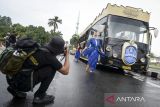 Fotografer memotret model memeragakan busana batik di Kota Tangerang, Banten, Kamis (2/10/2025). Komunitas Taman Potret bersama Perempuan Berkebaya Indonesia menggelar kegiatan hunting foto parade batik di bus Jawara dalam rangka memperingati Hari Batik Nasional sekaligus mengasah kemampuan dan kreativitas pegiat fotografi. ANTARA FOTO/Putra M. Akbar/gp