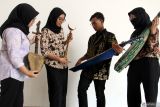 Sejumlah pengunjung mencoba memainkan alat musik petik tradisional dalam pameran Ruang Budaya bertema Nada Nusantara: Merangkai Harmoni Tradisi di Malang, Jawa Timur, Jumat (3/10/2025). Pameran yang berlangsung hingga Sabtu (4/10) itu menampilkan puluhan koleksi busana adat dan alat musik tradisional nusantara sebagai upaya untuk merawat tradisi sekaligus menumbuhkan apresiasi masyarakat terhadap keragaman budaya Indonesia. ANTARA Jatim/Ari Bowo Sucipto/mas.