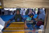Perajin memperagakan proses menenun dengan alat tenun tradisional saat acara Festival Pesona Wastra Indramayu, di Gedung Eks Landraad, Indramayu, Jawa Barat, Selasa (7/10/2025). Festival yang digelar Dinas Pendidikan dan Kebudayaan (Disdikbud) Kabupaten Indramayu itu untuk mengenalkan warisan kain tradisional pada generasi muda. ANTARA FOTO/Dedhez Anggara/agr