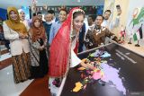 Mahasiswi Universitas Muhammadiyah (UM) Surabaya asal Afganistan Fawzia Gawhari menancapkan bendera pada peta dunia disaksikan Rektor UM Surabaya Mundakir (ketiga kiri) saat peluncuran Global Hub di Surabaya, Jawa Timur, Selasa (7/10/2025).  Peresmian Global Hub tersebut merupakan bentuk komitmen UM Surabaya dalam memperkuat jejaring internasional dan membangun semangat perdamaian global melalui pendidikan sekaligus memperkuat kolaborasi riset lintas negara, serta menjadikan kampus sebagai ruang inklusif bagi semua insan akademik tanpa batas geografis dan ideologis. ANTARA Jatim/Moch Asim.