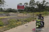 Pengendara sepeda motor melintas di dekat lokasi ditemukannya cemaran Cesium-137 (Cs-137) di Kawasan Industri Modern Cikande, Kabupaten Serang, Banten, Rabu (8/10/2025). Kementerian Lingkungan Hidup menyiapkan langkah relokasi sementara bagi warga yang tinggal di sekitar titik radiasi Cs-137 hingga proses dekontaminasi tuntas dan area dinyatakan netral. ANTARA FOTO/Angga Budhiyanto/gp