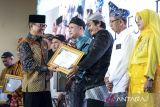 Menteri Desa dan Pembangunan Daerah Tertinggal Yandri Susanto (kiri) menyerahkan piagam kepada kepala desa terpilih saat acara penghargaan desa berkinerja baik dalam konvergensi penurunan stunting di Curug, Kabupaten Tangerang, Banten, Rabu (8/10/2025). Kementerian Desa dan Pembangunan Daerah Tertinggal memberikan penghargaan kepada 15 desa terpilih yang berhasil menekan angka stunting guna mewujudkan Asta Cita Presiden Prabowo Subianto dalam memperkuat pembangunan sumber daya manusia. ANTARA FOTO/Putra M. Akbar/gp