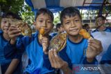 Siswa Sekolah Dasar menunjukkan makanan olahan dari ikan saat kampanye Gerakan Memasyarakatkan Makan Ikan (Gemarikan) di Taman Cimanuk, Indramayu, Jawa Barat, Sabtu (11/10/2025). Kegiatan yang digelar Dinas Perikanan dan Kelautan (Diskanla) Indramayu itu untuk mengampanyekan gerakan konsumsi ikan kepada seluruh masyarakat demi terciptanya generasi penerus bangsa yang berkualitas. ANTARA FOTO/Dedhez Anggara/agr