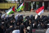 Sejumlah santri mengibarkan bendera Palestina saat mengikuti aksi bela Palestina di Kota Serang, Banten, Sabtu (11/10/2025). Aksi tersebut digelar dengan penggalangan dana bantuan serta doa bersama untuk masyarakat Palestina sebagai wujud solidaritas sesama umat manusia. ANTARA FOTO/Muhammad Bagus Khoirunas/gp