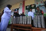 Guru bersama petugas Babinsa melakukan pengecekan Makanan Bergizi Gratis (MBG)  saat launching perdana di  Sekolah Madrasyah Ibtidaiyah Negeri (MIN) 18 desa Biluy, kecamatan Darul Kamal, kabupaten Aceh Besar, Aceh, Senin (13/10/2025). Badan Gizi Nasional berupaya memperluas jangkuan program Makan Bergizi Gratis (MBG) hingga ke wilayah pedalaman di Aceh dengan melakukan launching serentak MBG di lima sekolah berbeda jenjang pendidikan  dengan total penerima sebanyak 1.192 siswa. ANTARA FOTO/Ampelsa.