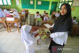 Guru  membagikan  Makanan Bergizi Gratis (MBG)  saat launching perdana di  Sekolah Madrasyah Ibtidaiyah Negeri (MIN) 18 desa Biluy, kecamatan Darul Kamal, kabupaten Aceh Besar, Aceh, Senin (13/10/2025). Badan Gizi Nasional berupaya memperluas jangkuan program Makan Bergizi Gratis (MBG) hingga ke wilayah pedalaman di Aceh dengan melakukan launching serentak MBG di lima sekolah berbeda jenjang pendidikan  dengan total penerima sebanyak 1.192 siswa. ANTARA FOTO/Ampelsa.