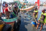 Stabilisasi harga ikan. Nelayan membongkar ikan hasil tangkapan dari perahunya di Tempat Pelelangan Ikan (TPI) Pelabuhan Muncar, Banyuwangi, Jawa Timur, Selasa (14/10/2025). Kesatuan Nelayan Tradisional Indonesia (KNTI) mendorong pemerintah membentuk stabilisasi harga serupa dengan peran Bulog pada komoditas pangan pokok, karena harga ikan ditingkat nelayan masih berfluktuasi dan cenderung rendah akibat lemahnya posisi tawar nelayan kecil. Antara Jatim/Budi Candra Setya/um
