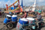 Pekerja mengantarkan es untuk kebutuhan nelayan di Tempat Pelelangan Ikan (TPI) Pelabuhan Muncar, Banyuwangi, Jawa Timur, Selasa (14/10/2025). Kesatuan Nelayan Tradisional Indonesia (KNTI) mendorong pemerintah membentuk stabilisasi harga serupa dengan peran Bulog pada komoditas pangan pokok, karena harga ikan ditingkat nelayan masih berfluktuasi dan cenderung rendah akibat lemahnya posisi tawar nelayan kecil. Antara Jatim/Budi Candra Setya/um