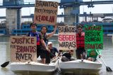 Sejumlah aktivis lingkungan dari Ecoton membentangkan poster di atas perahu saat aksi Besuk Sungai Brantas di Surabaya, Jawa Timur, Selasa (14/10/2025). Aksi itu menyerukan sejumlah aspirasi di antaranya mengajak masyarakat menjaga kualitas air sungai Brantas dengan tidak membuang sampah ke sungai, mewajibkanÂ  perusahaan industri mengolah limbah terlebih dahulu sampai memenuhi baku mutu sebelum dibuang ke sungai dan mengimbau pemerintah setempat membentuk badan khusus pengelola sungai Brantas yang mengawasi kualitas dan kelestarian ekosistem sungai Brantas. ANTARA Jatim/Didik Suhartono/mas.