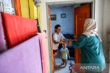 Ibu dari seorang balita menerima Makanan Bergizi Gratis (MBG) di Desa Cileunyi Wetan, Kabupaten Bandung, Jawa Barat, Rabu (15/10/2025). Pemerintah Desa Cileunyi Wetan telah mendistribusikan MBG kepada 300 warga yang terdiri dari balita, ibu hamil dan ibu menyusui sejak 1 Oktober 2025 yang diharapkan mampu mengentaskan gizi buruk dan anak stunting di wilayah tersebut. ANTARA FOTO/Raisan Al Farisi/agr