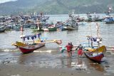 Nelayan menepikan kapal miliknya di kolam labuh Pelabuhan Perikanan Pantai (PPP) Popoh, Tulungagung, Jawa Timur, Rabu (15/10/2025). Pemerintah menyiapkan pengembangan dermaga 2 dan fasilitas cold storage di pelabuhan ini untuk meningkatkan efisiensi bongkar muat hasil tangkap, demi memperkuat pelabuhan pantai selatan ini sebagai hub logistik perikanan nasional. ANTARA Jatim/Destyan Sujarwoko/mas.