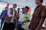 Bupati Lumajang Indah Amperawati Masdar (depan kiri) menyerahkan sertifikat tanah program Pendaftaran Tanah Sistematis Lengkap (PTSL) kepada warga di Balai Desa Jugosari, Lumajang, Jawa Timur, Jumat (17/10/2025). Badan Pertanahan Nasional (BPN) Lumajang menyerahkan sebanyak 6.000 sertifikat tanah program PTSL tahun 2025 secara bertahap, baik dalam bentuk fisik maupun elektronik, guna mencegah terjadinya penggandaan atau penipuan sertifikat. Antara Jatim/Irfan Sumanjaya/um
