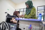 Guru menyuapi siswa penyandang disabilitas hidangan makan bergizi gratis (MBG) di SLBN Trituna Subang, Kabupaten Subang, Jawa Barat, Kamis (16/10/2025). Sebanyak 146 siswa SLBN Trituna Subang menjadi penerima manfaat program Makan Bergizi Gratis (MBG) yang digulirkan pemerintah sebagai salah satu program prioritas nasional. ANTARA FOTO/Abdan Syakura/agr
