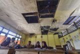 Pelajar kelas II mengikuti kegiatan belajar mengajar di SDN 94 Lagan Ulu, Geragai, Tanjung Jabung Timur, Jambi, Kamis (16/10/2025). Sekolah yang saat ini memiliki 37 murid di salah satu perkampungan tua di Tanjung Jabung Timur itu dalam kondisi rusak pada plafon dan lantai sehingga membahayakan guru dan siswa, serta telah 33 tahun lebih melakukan kegiatan belajar mengajar dengan cara disekat untuk empat rombongan belajar (rombel). ANTARA FOTO/Wahdi Septiawan/nz.