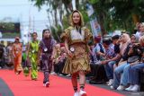 Sejumlah model memperagakan busana batik khas Banyuwangi pada acara Fashion on Pedestrian di Gesibu, Banyuwangi, Jawa Timur, Jumat (17/10/2025). Pemerintah daerah Banyuwangi menggelar acara tersebut sebagai sarana mempromosikan batik lokal yang kaya motif sekaligus menjadi wadah kreativitas desainer muda guna mendukung industri kreatif dan ekonomi lokal. ANTARA Jatim/Budi Candra Setya/mas.