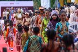 Sejumlah model memperagakan busana batik khas Banyuwangi pada acara Fashion on Pedestrian di Gesibu, Banyuwangi, Jawa Timur, Jumat (17/10/2025). Pemerintah daerah Banyuwangi menggelar acara tersebut sebagai sarana mempromosikan batik lokal yang kaya motif sekaligus menjadi wadah kreativitas desainer muda guna mendukung industri kreatif dan ekonomi lokal. ANTARA Jatim/Budi Candra Setya/mas.