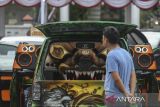 Pengunjung melihat mobil modifikasi saat kontes Indonesia Automotive Society (IAS) Banten Auto Modify di Alun-alun Barat Kota Serang, Banten, Sabtu (18/10/2025). Kontes yang diikuti sekitar 160 mobil modifikasi tersebut diselenggarakan sebagai wadah untuk menampilkan kreativitas dan ajang silaturahmi para pecinta mobil modifikasi sekaligus memeriahkan HUT ke-25 Provinsi Banten. ANTARA FOTO/Angga Budhiyanto/gp