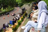 Warga menyaksikan peserta yang melaju di area lintasan saat mengikuti balapan Lomba Kereta Peti Sabun 2025 di kawasan Sasana Budaya Ganesha ITB, Bandung, Jawa Barat, Sabtu (18/10/2025). Kompetisi adu kecepatan kendaraan kreatif tanpa mesin yang mengandalkan daya gravitasi tersebut merupakan bagian rangkaian kemeriahan Pasar Seni ITB 2025 yang diikuti sedikitnya 75 peserta dari sejumlah kampus dan sekolah kejuruan untuk melintasi lintasan balap sepanjang 250 meter. ANTARA FOTO/Novrian Arbi/agr