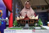 Guru Sekolah Dasar Dewi Roani memperlihatkan replika Rumah Gadang karya muridnya, Wildan Azizi, pada acara Pementasan dan Pameran Gerakan Seniman Masuk Sekolah di Pontianak, Kalimantan Barat, Kamis (16/10/2025). Acara tersebut menampilkan beragam karya seni dari 88 siswa lima sekolah di Pontianak yang mendapat pendampingan seniman Kalbar dalam menghasilkan karya berupa lukisan, tarian, pembuatan film, kerajinan kriya, serta pentas musik dan budaya guna menumbuhkan minat dan bakat di bidang seni budaya sekaligus mempererat sinergi antara sekolah dan seniman. ANTARA FOTO/Jessica Wuysang