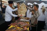 Bupati Tulungagung Gatut Sunu Wibowo (kiri) memegang anak wayang gunung di booth Kedaton wayang Sukharjo usai pembukaan Pameran temporer Museum Daerah Tulungagung, Jawa Timur, Selasa (21/10/2025). Pameran yang digelar dalam rangkaian HUT ke-820 Kabupaten Tulungagung itu diikuti enam museum daerah Jateng-Jatim bertujuan menumbuhkan rasa cinta masyarakat terhadap museum sebagai etalase peradaban bangsa. Antara Jatim/Destyan Sujarwoko/um